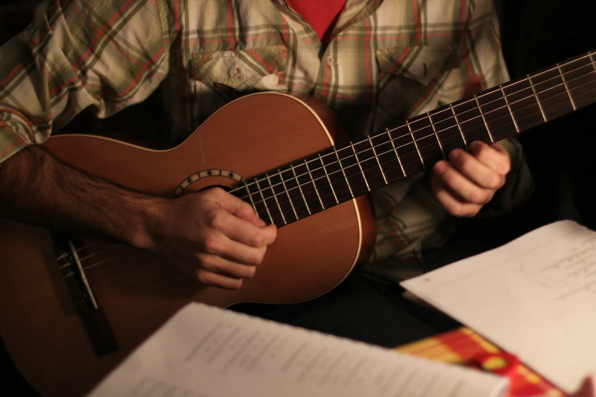 un homme qui joue de la guitare à sa table